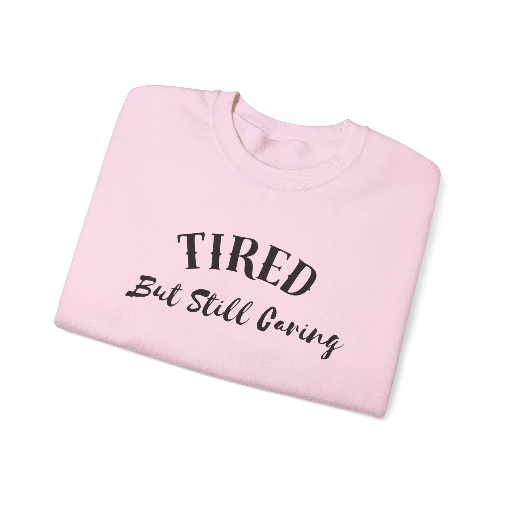 Front view of Tired But Still Caring Sweatshirt with simple type design