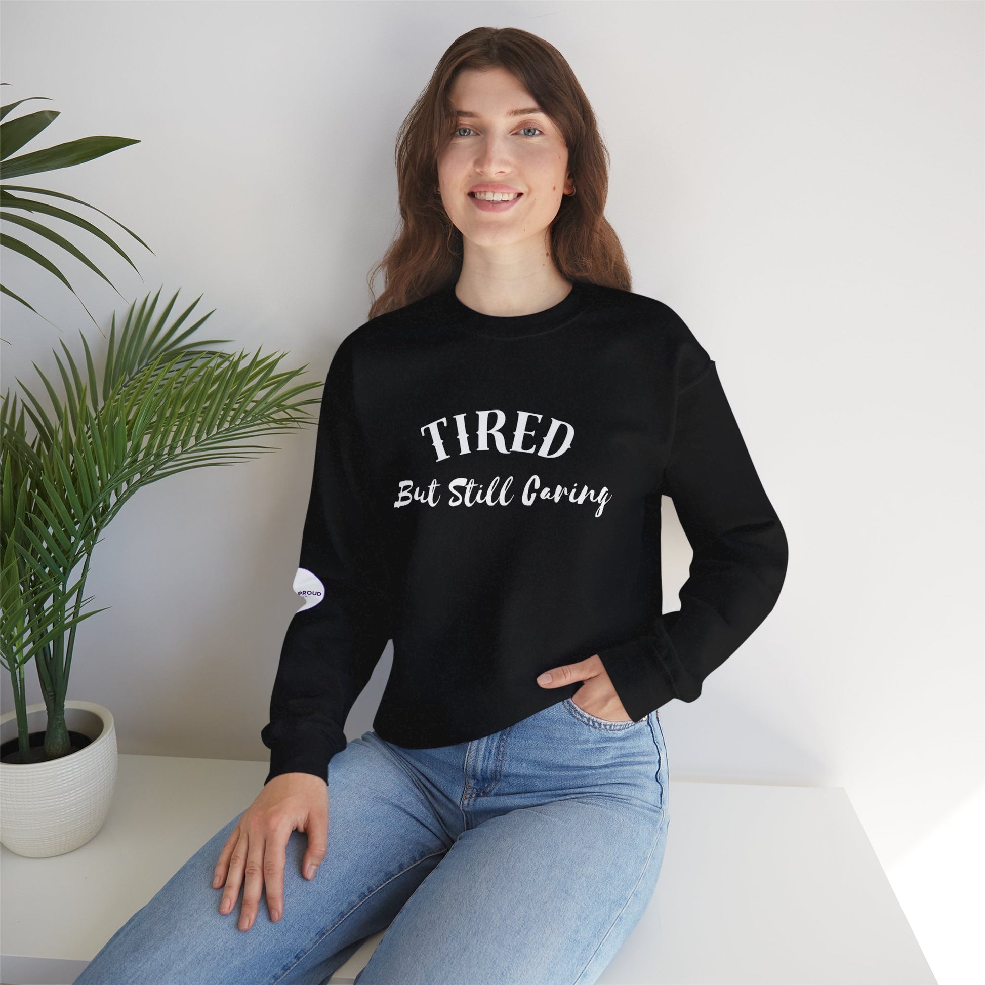 Front view of Tired But Still Caring Sweatshirt with simple type design